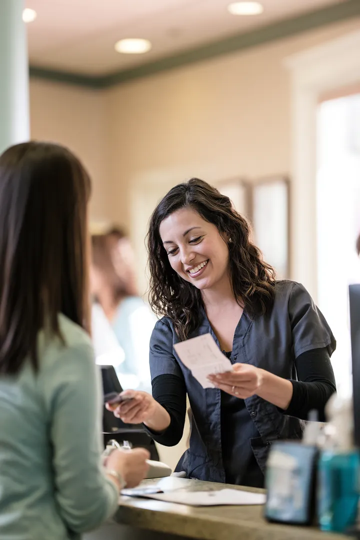 Patient settling a dental bill at a friendly office front desk
