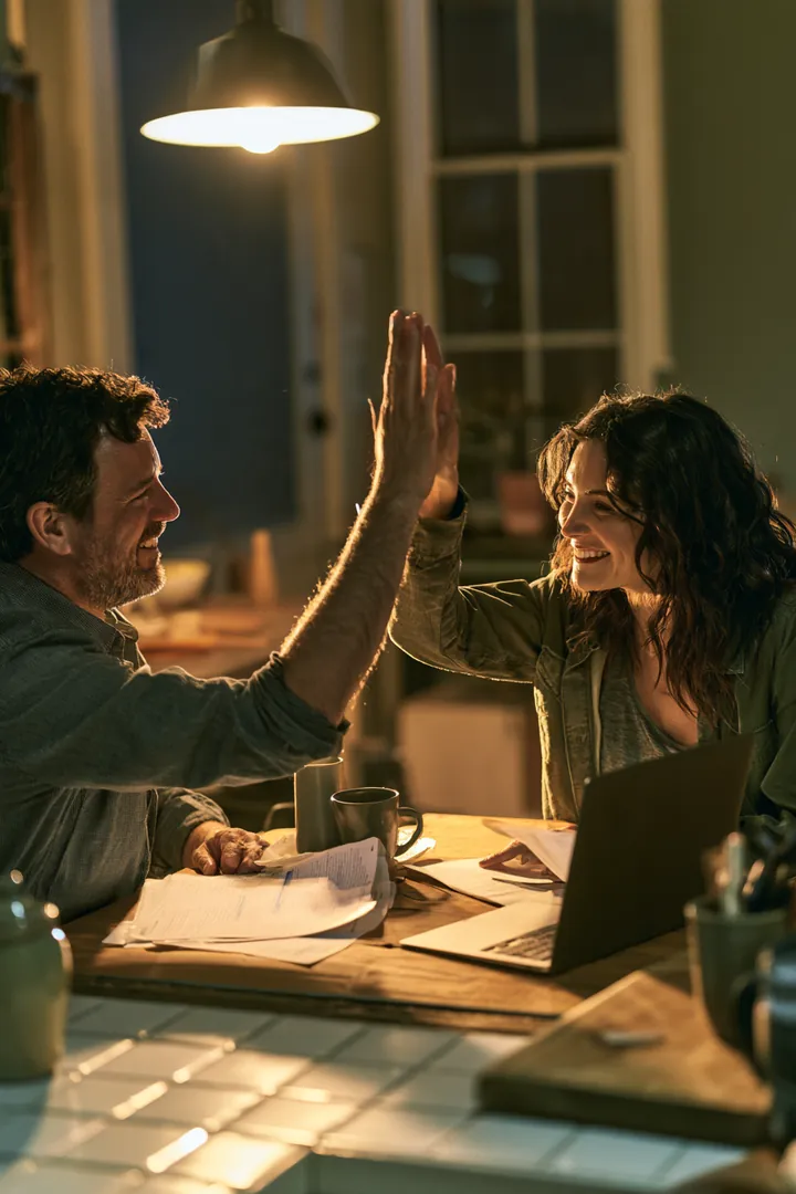 Couple celebrating with a high five after paying off their consolidated statements