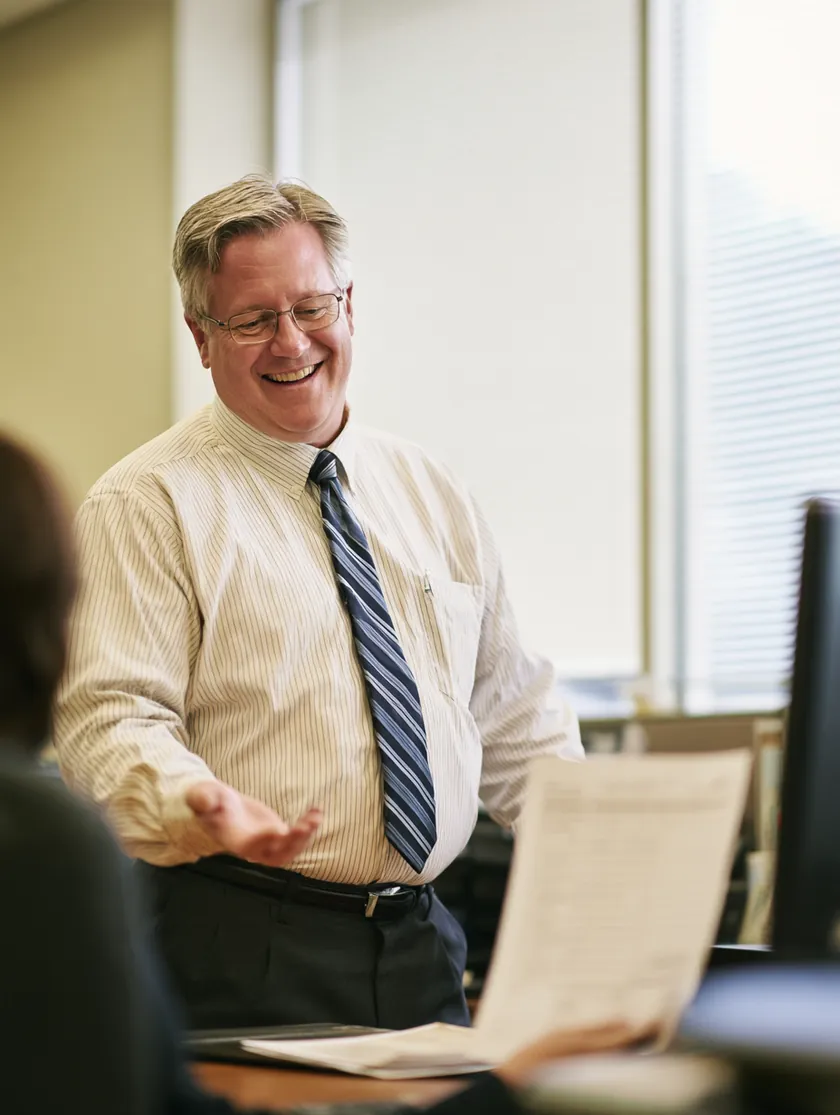 Advisor sketching the five loan process steps on a glass wall for a client